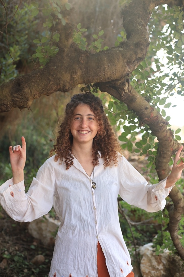 קארין מחייכת מתחת לעץ